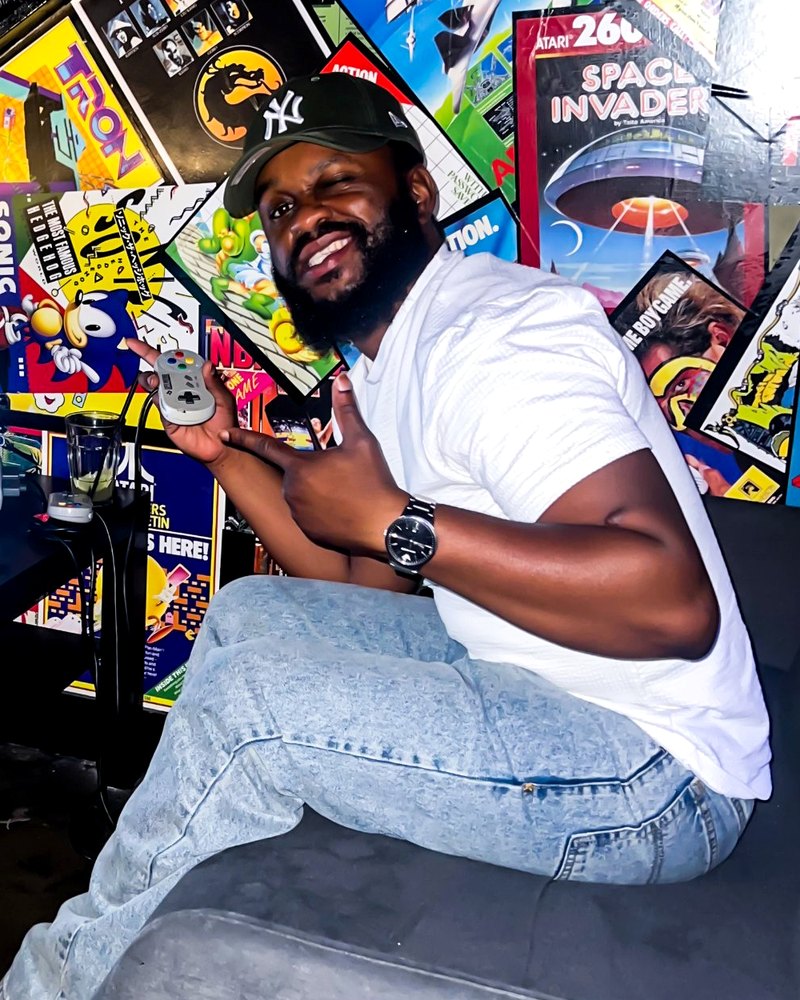 Kerveland smiling with a retro games controller in an arcade bar